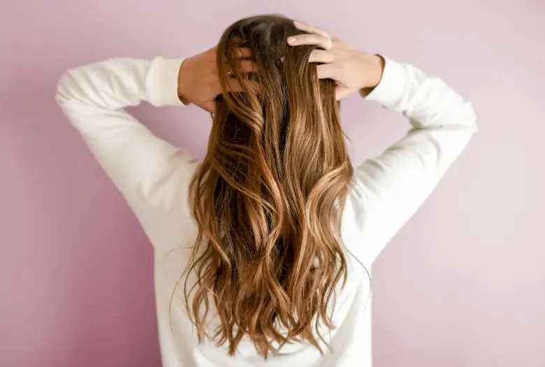 A girl is showing her long hair from the back, highlighting natural growth.