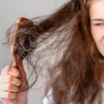 Girl with tangled hair in comb, worried about bentonite clay damage