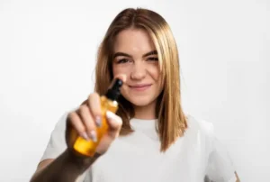 Beautiful girl holding hair oil bottle for nourished and shiny hair